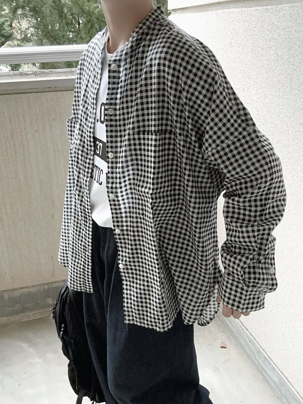 ブラック系のシャツ/ブラウス、ホワイト系のTシャツ/カットソー、ブルー系のデニムパンツを着用したレディースの冬コーディネートの4枚目の写真