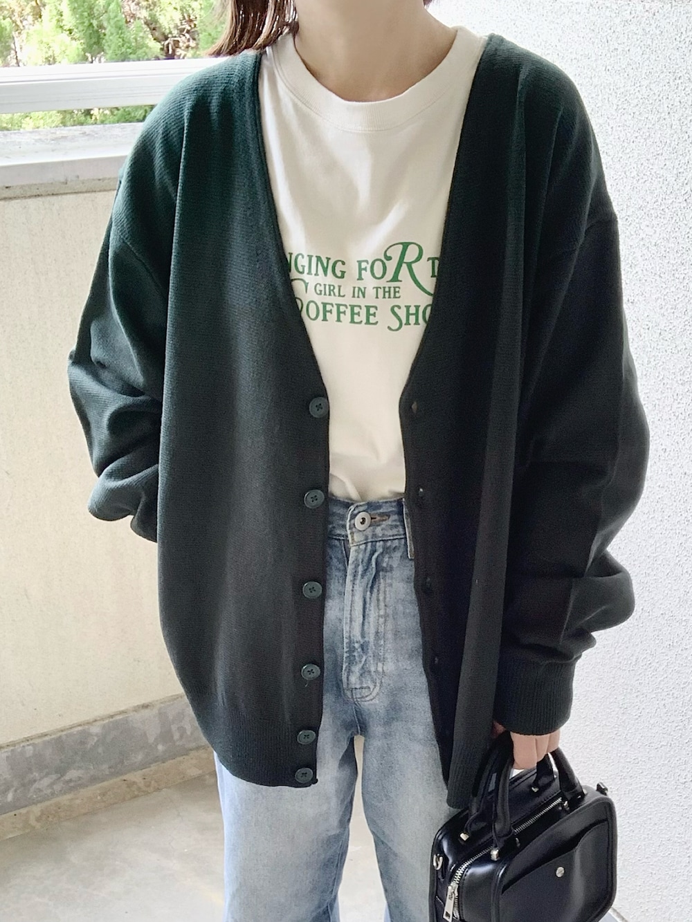 グリーン系のカーディガン/ボレロ、ホワイト系のTシャツ/カットソー、ブルー系のデニムパンツを着用したレディースの夏コーディネートの3枚目の写真