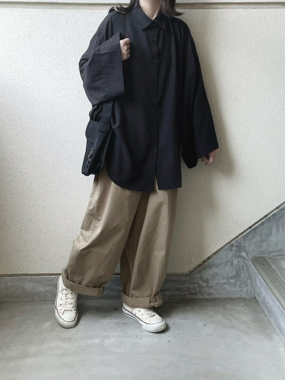 ブラック系のシャツ/ブラウス、ベージュ系のチノパンツ、ブラック系のショルダーバッグを着用したレディースの春コーディネートの5枚目の写真