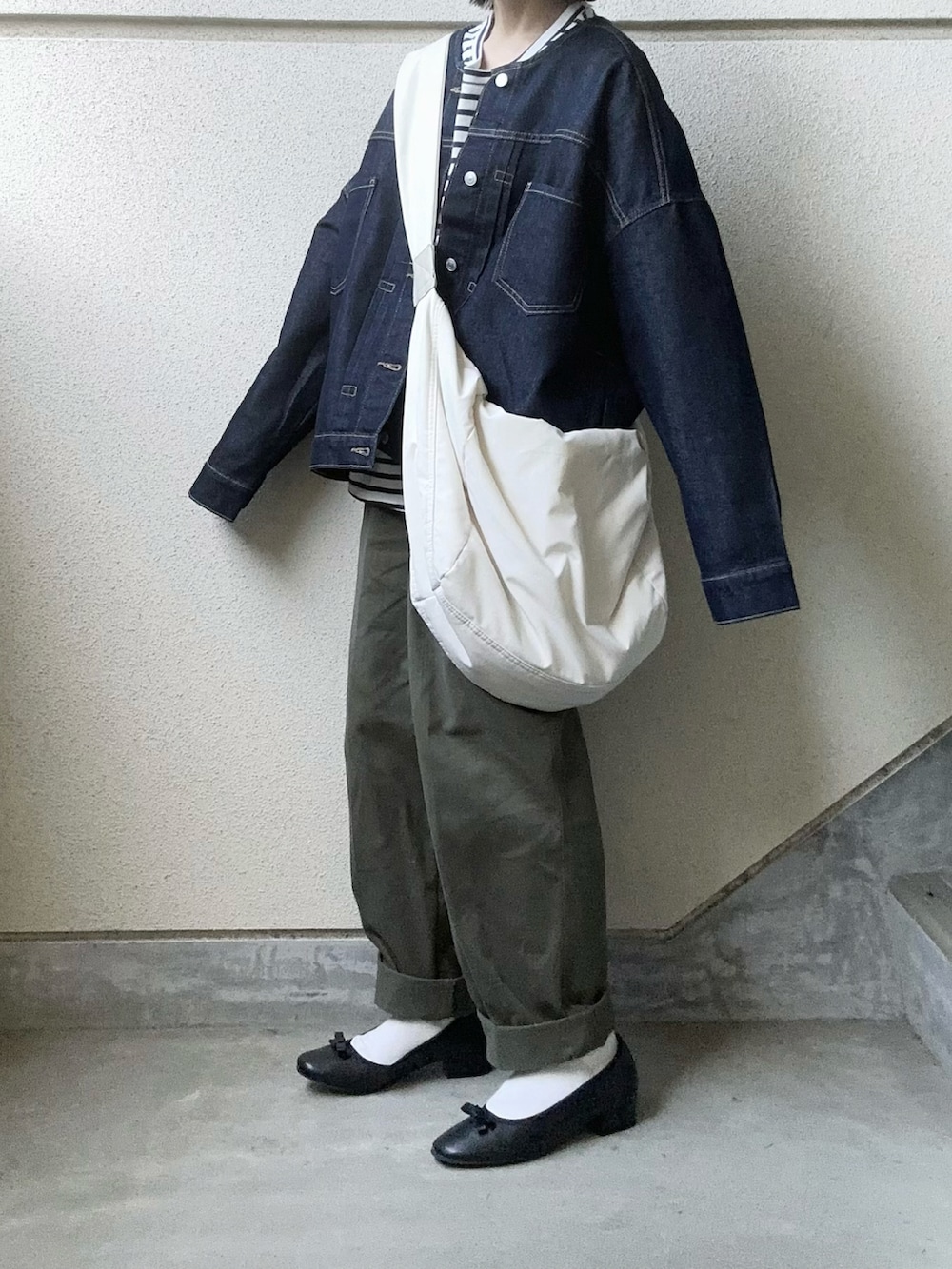 ブラック系のバレエシューズ、ブルー系のデニムジャケット、グリーン系のチノパンツを着用したレディースの夏コーディネートの4枚目の写真