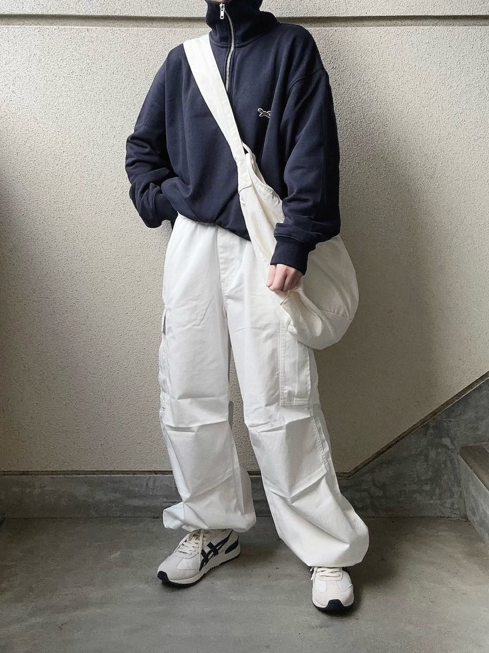 ホワイト系のカーゴパンツ、ブルー系のスウェット、ホワイト系のショルダーバッグを着用したレディースの冬コーディネートの3枚目の写真