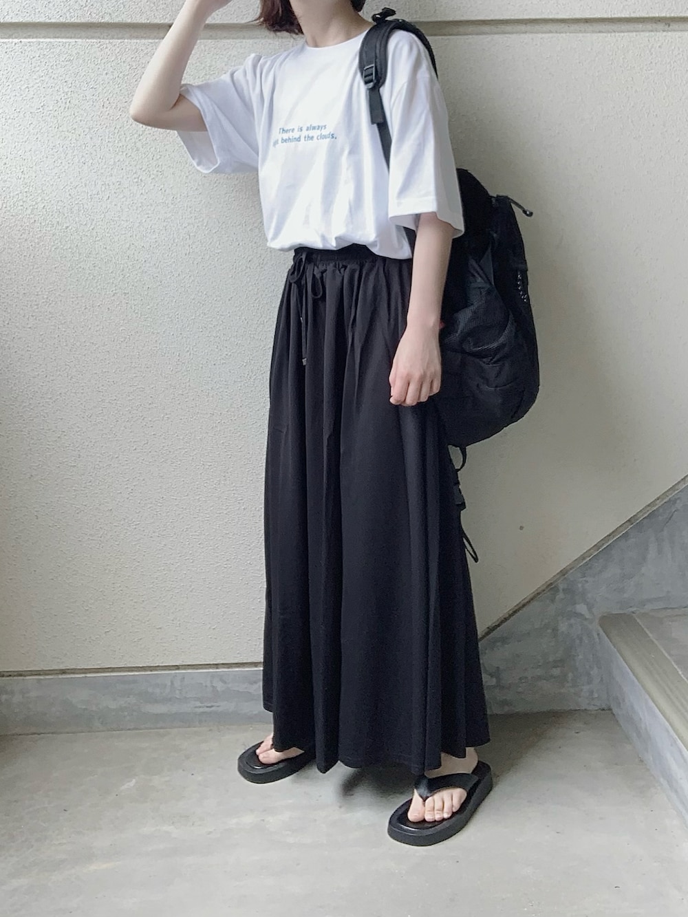 ブルー系のTシャツ/カットソー、ブラック系のスカート、ブラック系のサンダルを着用したレディースの春コーディネートの2枚目の写真