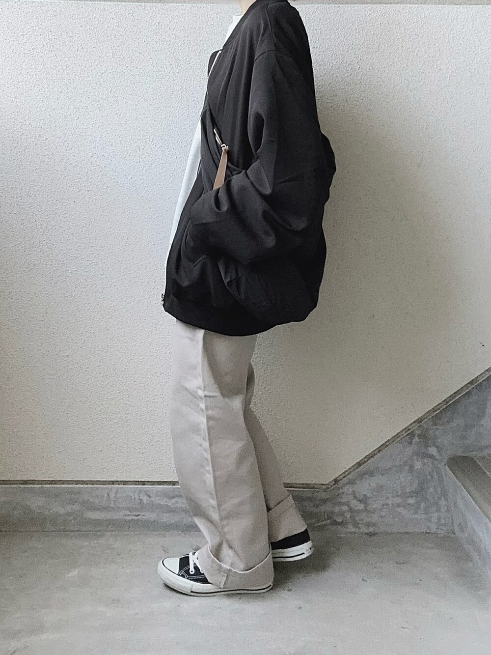 ブラック系のMA-1、ベージュ系のデニムパンツを着用したレディースの秋コーディネートの3枚目の写真