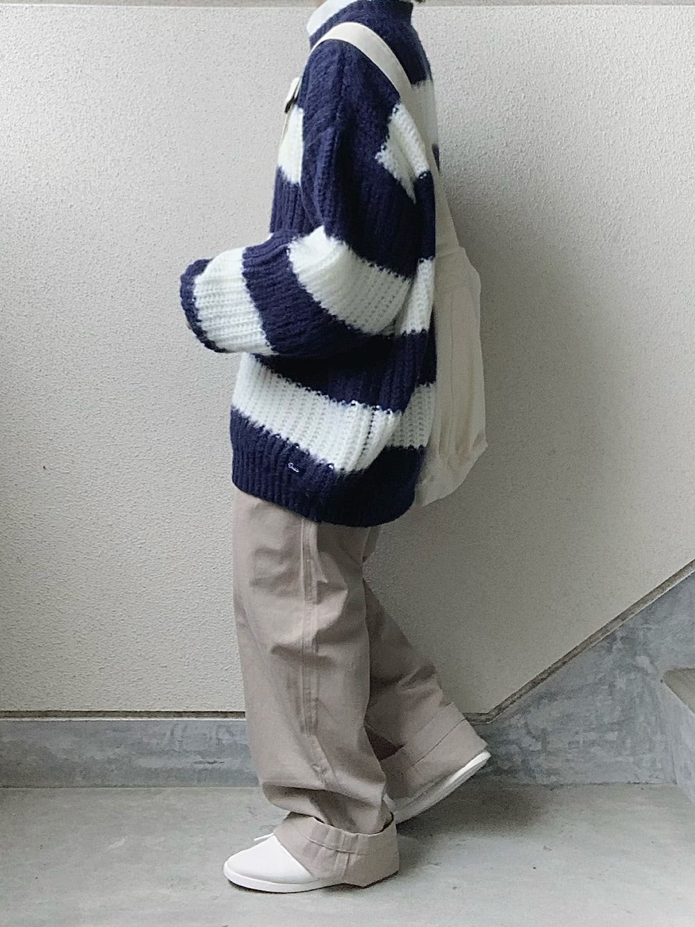 ブルー系のニット/セーター、ベージュ系のその他パンツ、ホワイト系のショルダーバッグを着用したレディースの秋コーディネートの2枚目の写真