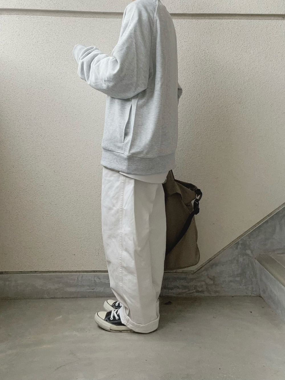 グレー系のスウェット、グリーン系のトートバッグを着用したレディースの冬コーディネートの2枚目の写真