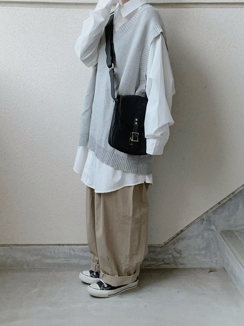 ホワイト系のシャツ/ブラウス、ブラック系のショルダーバッグ、ベージュ系のチノパンツを着用したレディースの冬コーディネートの4枚目の写真