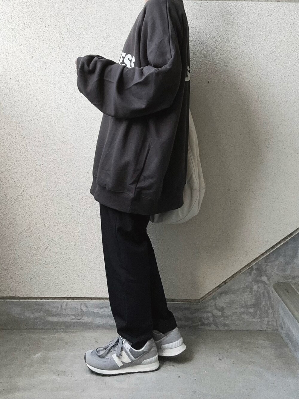 グレー系のスウェット、ブラック系のその他パンツ、ホワイト系のショルダーバッグを着用したレディースの秋コーディネートの4枚目の写真