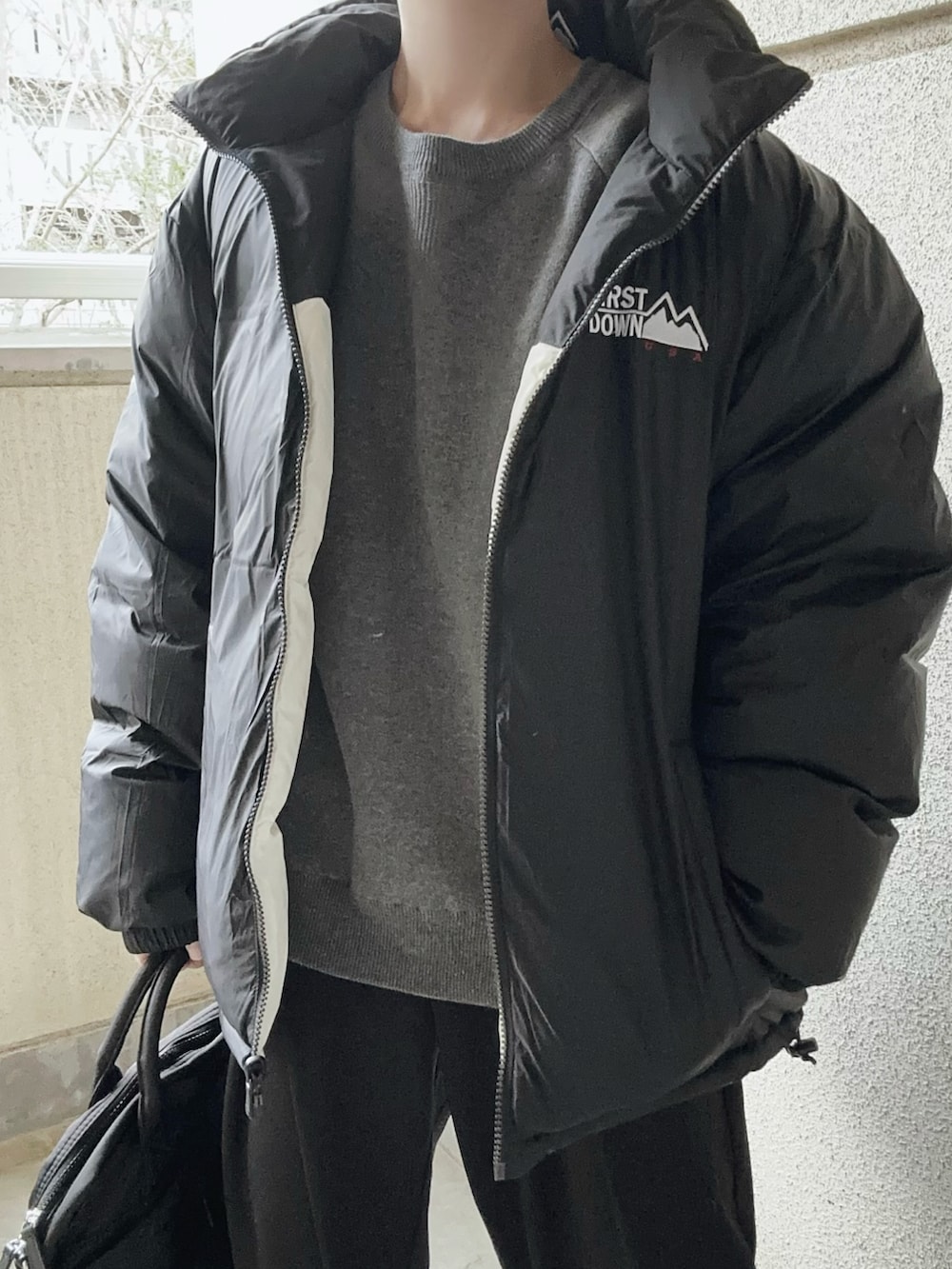 ホワイト系のダウンジャケット/コート、ブラック系のスラックス、グレー系のニット/セーターを着用したレディースの冬コーディネートの4枚目の写真