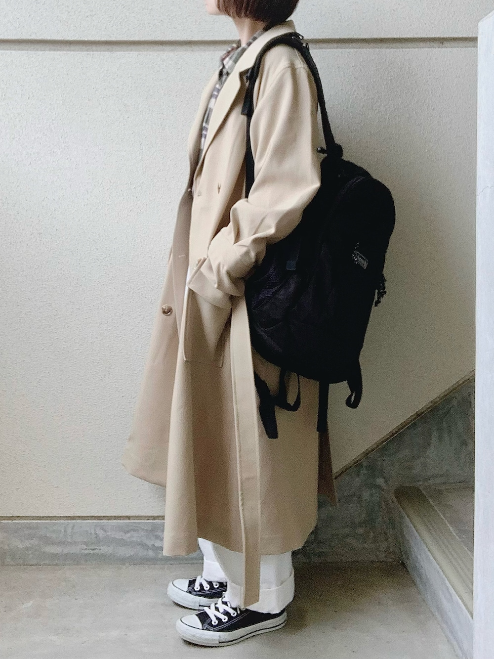 ベージュ系のトレンチコート、グリーン系のシャツ/ブラウス、ホワイト系のパンツを着用したレディースの冬コーディネートの2枚目の写真