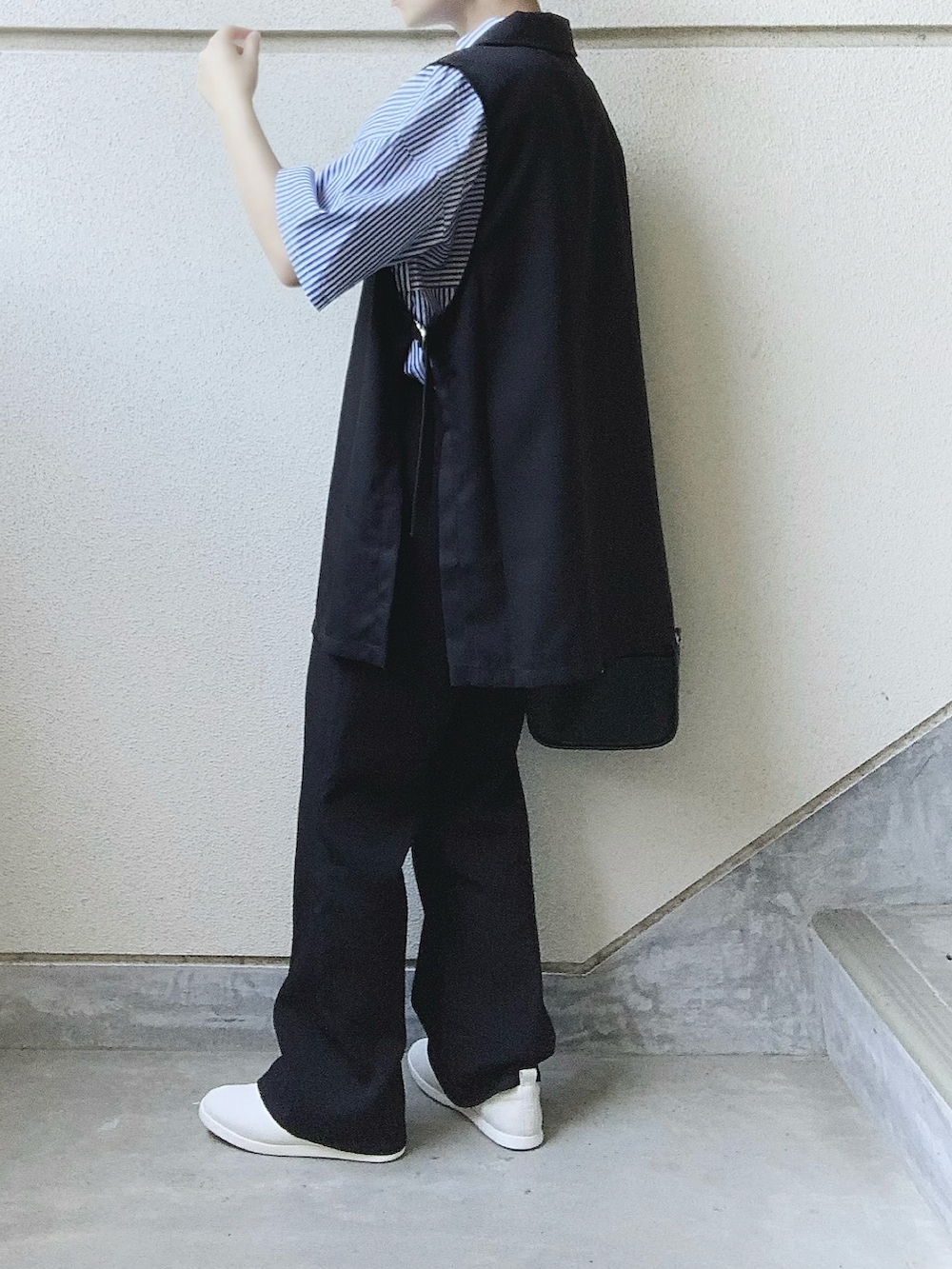 ブラック系のベスト、ブルー系のシャツ/ブラウス、ブラック系のスラックスを着用したレディースの夏コーディネートの2枚目の写真