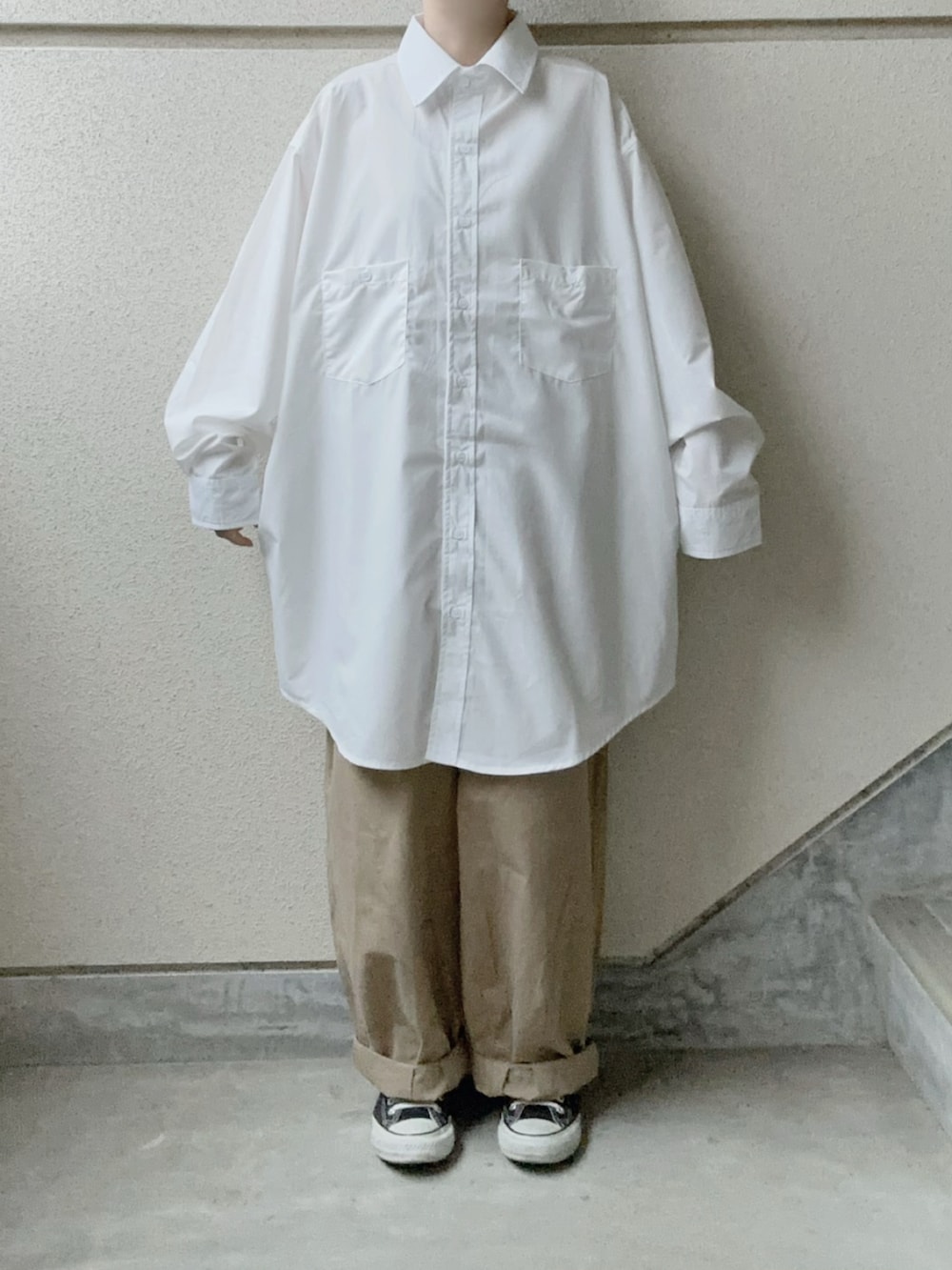 ホワイト系のシャツ/ブラウス、ベージュ系のチノパンツ、ブラック系のショルダーバッグを着用したレディースの冬コーディネートの3枚目の写真