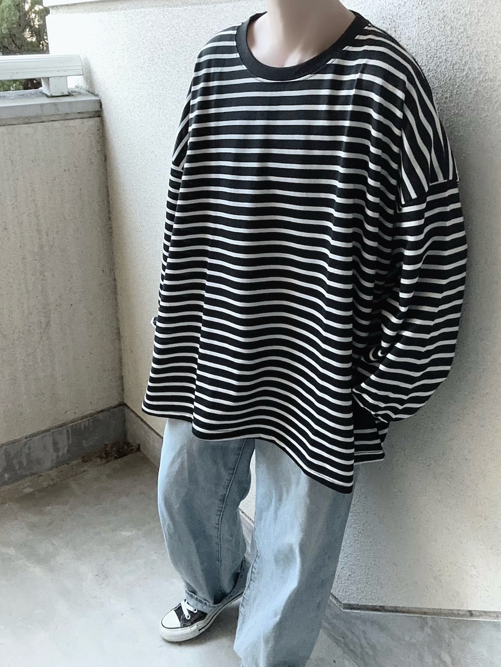 ブラック系のTシャツ/カットソー、ブラック系のショルダーバッグ、ブルー系のデニムパンツを着用したレディースの冬コーディネートの4枚目の写真