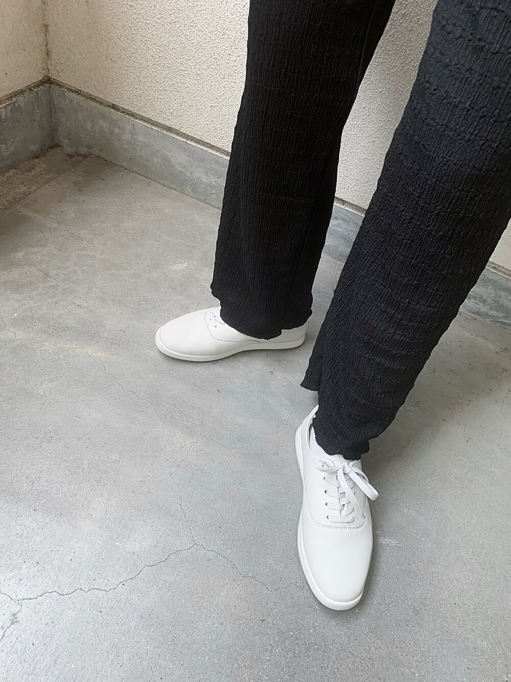 ホワイト系のシャツ/ブラウス、ホワイト系のスニーカー、ブラック系のスラックスを着用したレディースの夏コーディネートの3枚目の写真