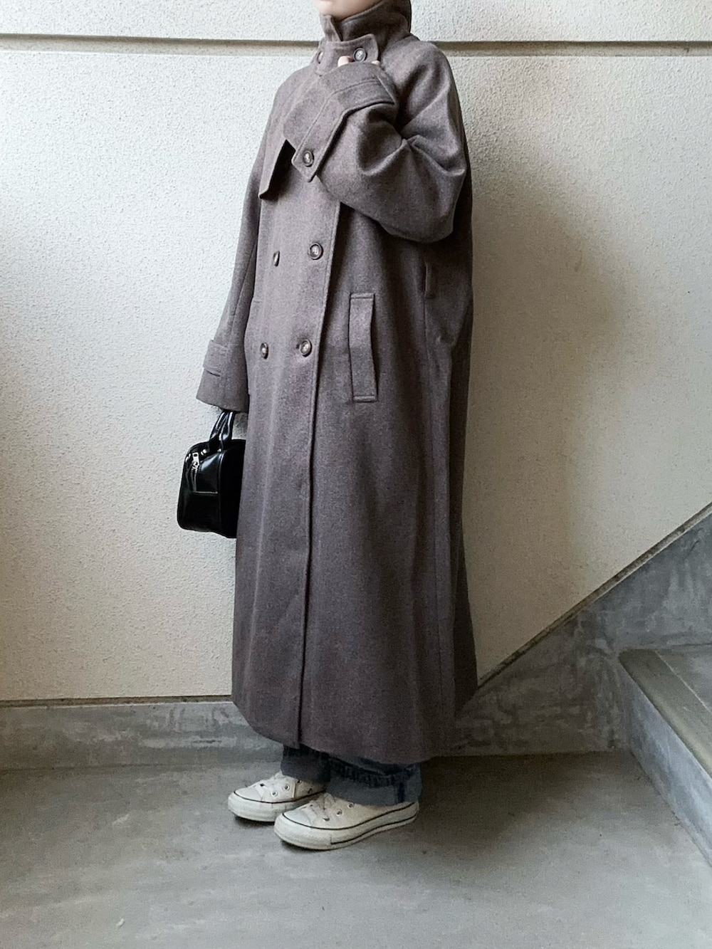 ブラウン系のチェスターコート、ブルー系のデニムパンツを着用したレディースの秋コーディネートの3枚目の写真