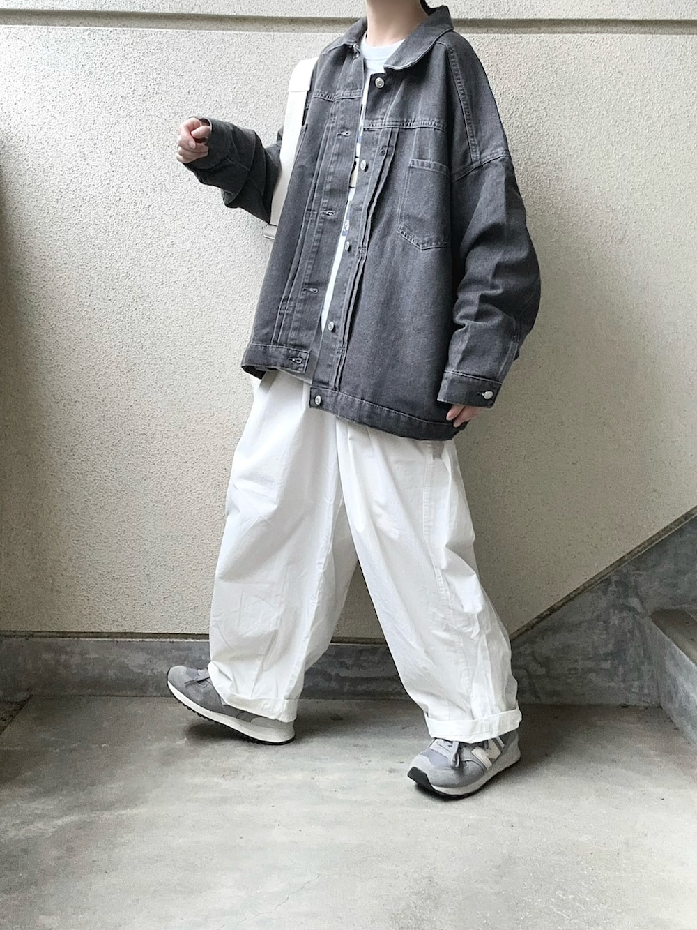 グレー系のデニムジャケット、ホワイト系のチノパンツを着用したレディースの秋コーディネートの2枚目の写真