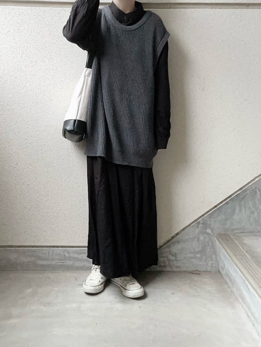 ブラック系のワンピース、グレー系のニット/セーター、ブラック系のトートバッグを着用したレディースの冬コーディネートの4枚目の写真