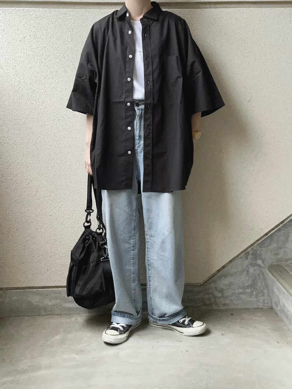 ブラック系のシャツ/ブラウス、ブラック系のショルダーバッグ、ブルー系のデニムパンツを着用したレディースの春コーディネートの4枚目の写真