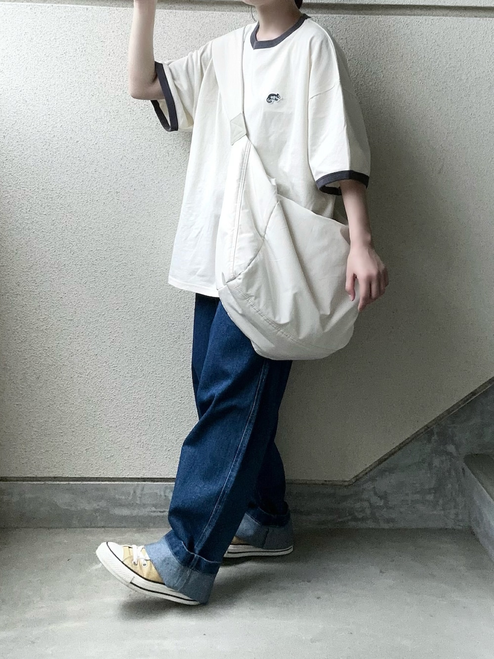 ブルー系のデニムパンツ、グレー系のTシャツ/カットソー、ホワイト系のショルダーバッグを着用したレディースの春コーディネートの3枚目の写真