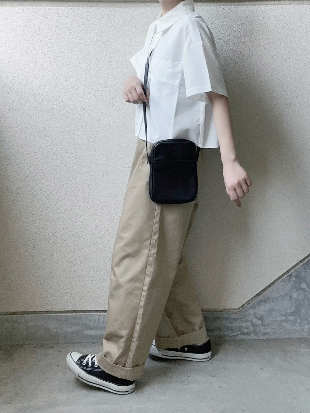 ホワイト系のシャツ/ブラウス、ベージュ系のチノパンツ、ブラック系のショルダーバッグを着用したレディースの春コーディネートの2枚目の写真