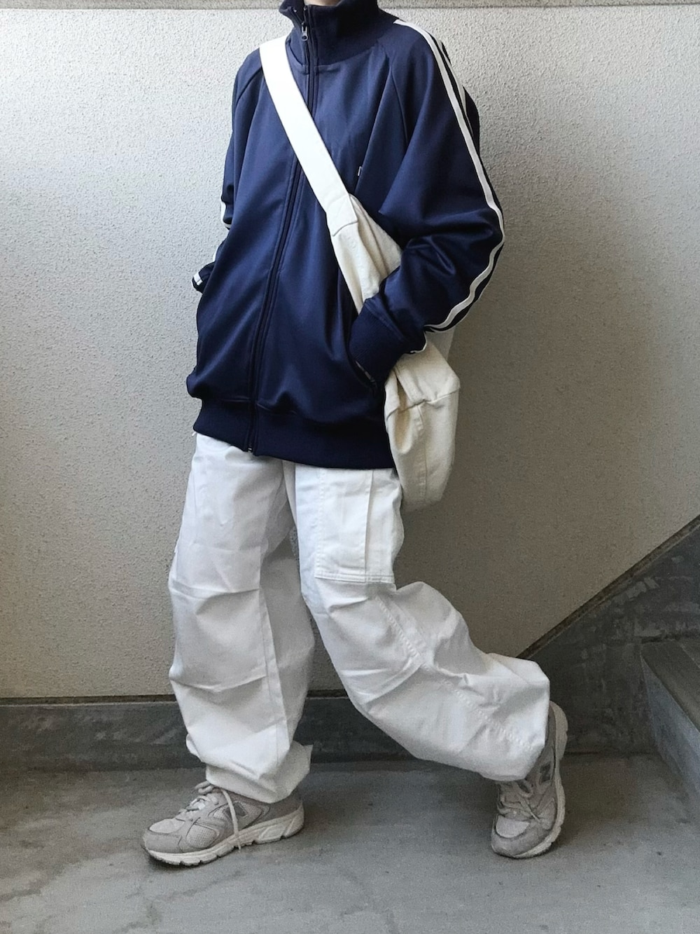 ホワイト系のカーゴパンツ、ブルー系のジャージ、グレー系のスニーカーを着用したレディースの春コーディネートの3枚目の写真