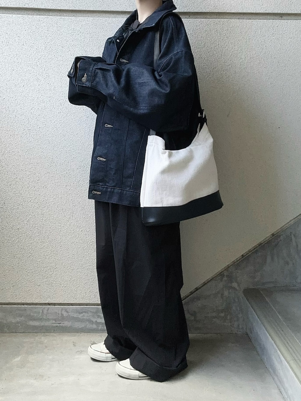 ブラック系のつなぎ/オールインワン、ブラック系のトートバッグ、ブルー系のデニムジャケットを着用したレディースの春コーディネートの4枚目の写真