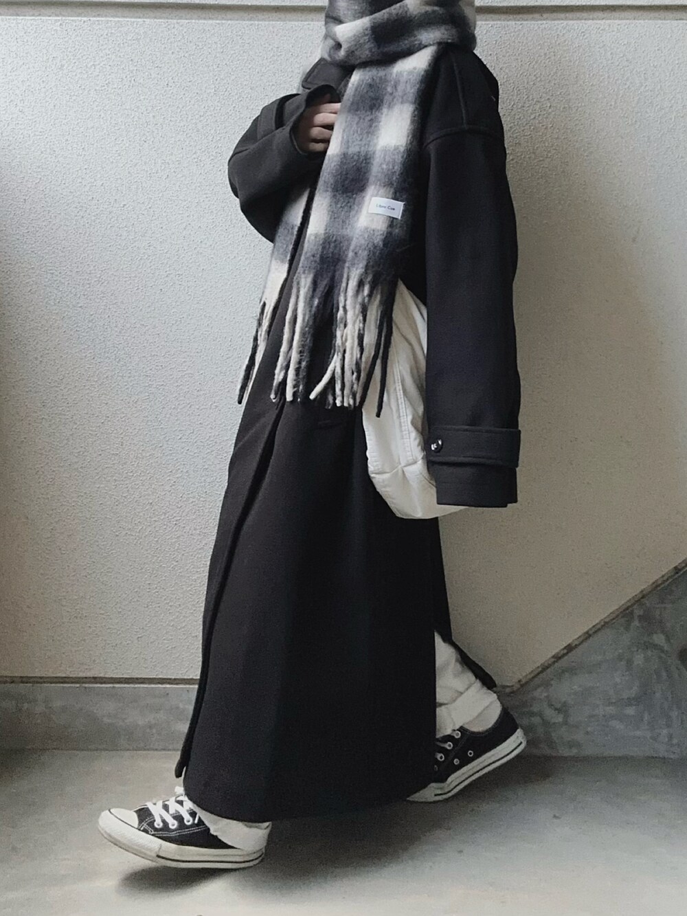 ブラック系のトレンチコート、ブラック系のマフラーを着用したレディースの冬コーディネートの2枚目の写真