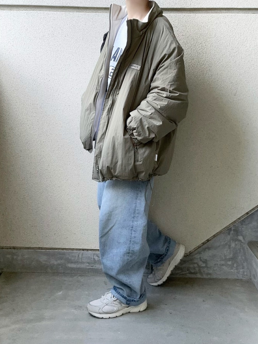 グリーン系のブルゾン、ブルー系のデニムパンツを着用したレディースの秋コーディネートの2枚目の写真