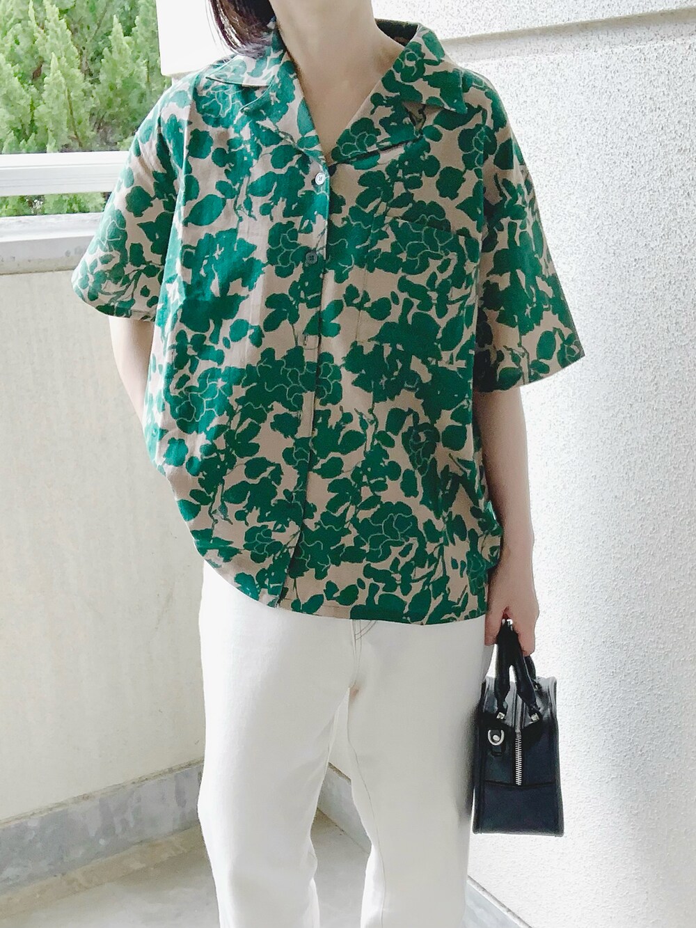 グリーン系のシャツ/ブラウス、ホワイト系のデニムパンツ、ブラック系のサンダルを着用したレディースの春コーディネートの3枚目の写真