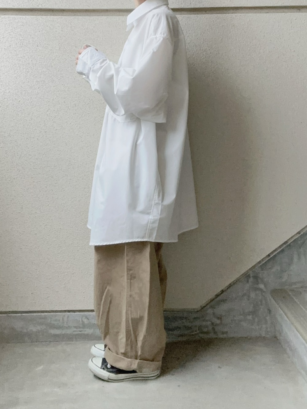 ホワイト系のシャツ/ブラウス、ベージュ系のチノパンツ、ブラック系のショルダーバッグを着用したレディースの冬コーディネートの5枚目の写真