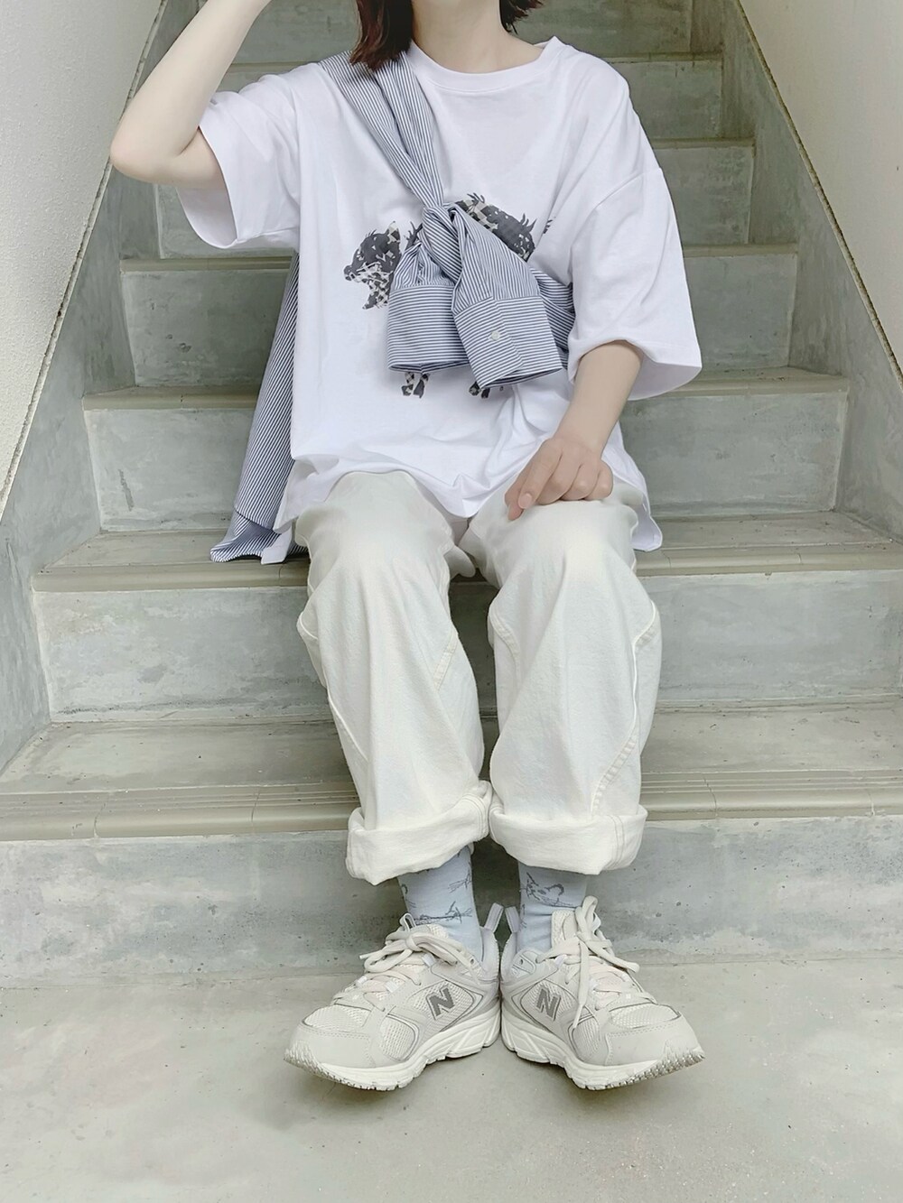 グレー系のTシャツ/カットソー、ホワイト系のパンツ、グレー系のスニーカーを着用したレディースの夏コーディネートの3枚目の写真