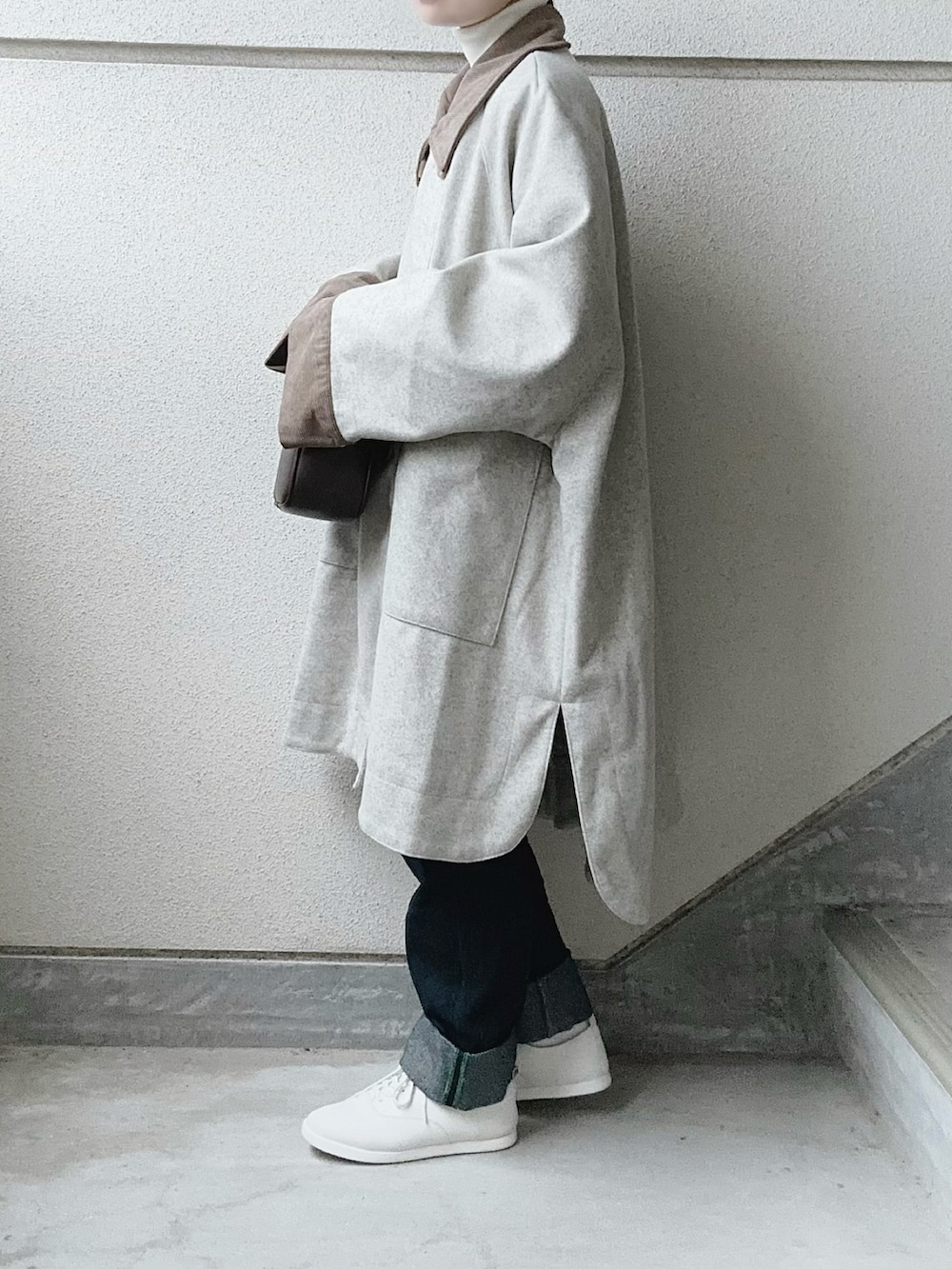 ベージュ系のその他アウター、ホワイト系のニット/セーター、ブラウン系のボストンバッグを着用したレディースの秋コーディネートの3枚目の写真