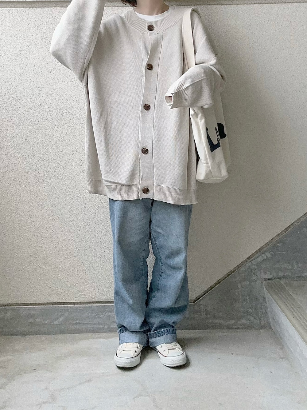 ベージュ系のカーディガン/ボレロ、ブルー系のデニムパンツ、ホワイト系のスニーカーを着用したレディースの冬コーディネートの5枚目の写真