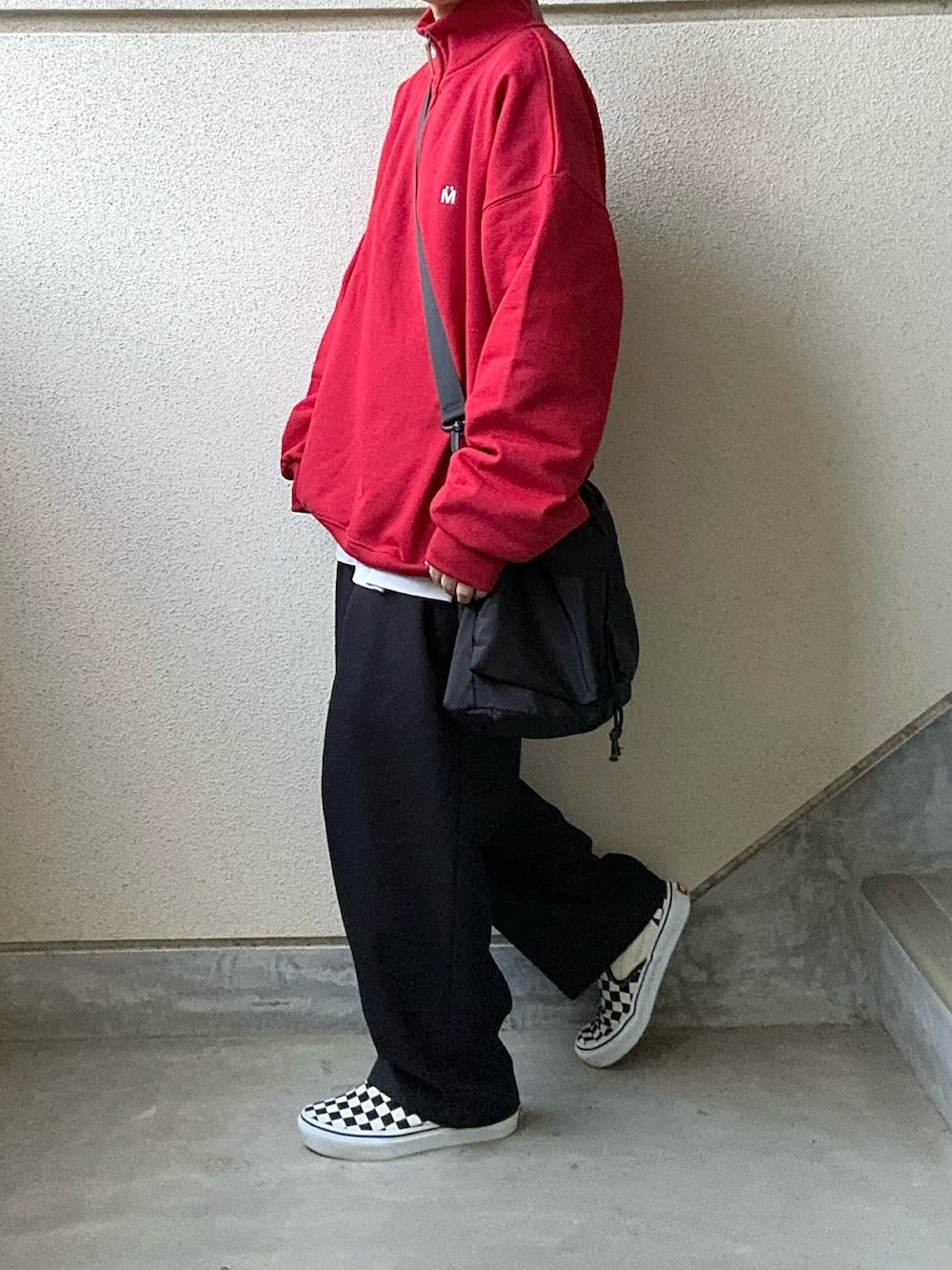 ブラック系のショルダーバッグ、レッド系のスウェットを着用したレディースの冬コーディネートの3枚目の写真