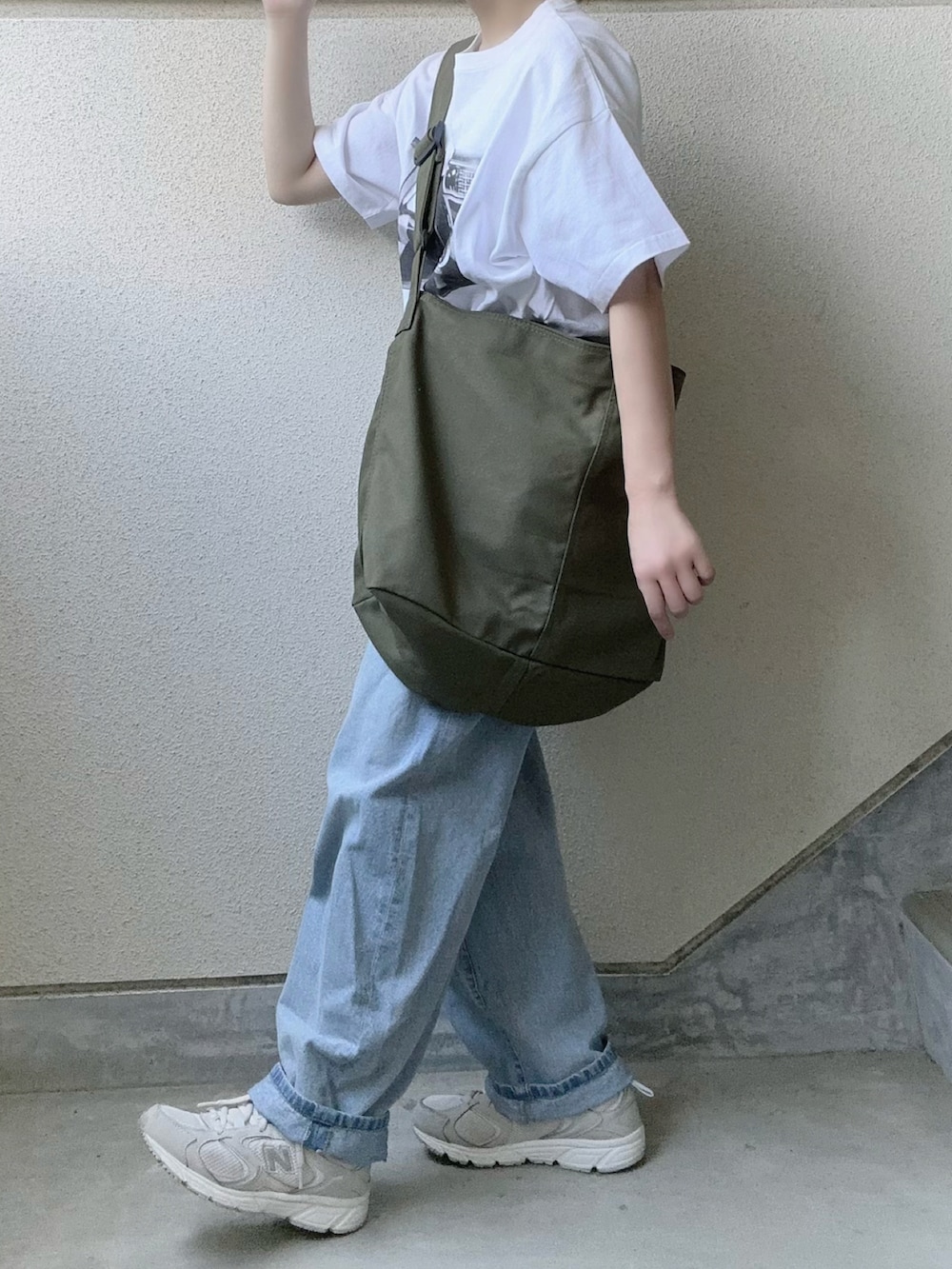 ブラック系のTシャツ/カットソー、グリーン系のショルダーバッグを着用したレディースの夏コーディネートの3枚目の写真