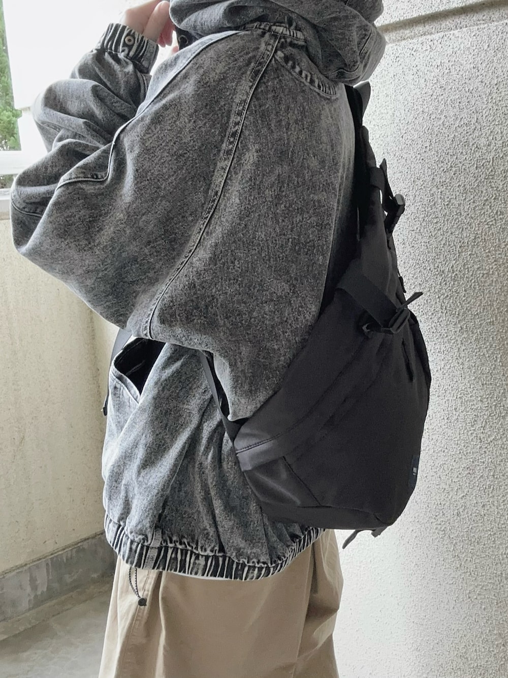 ブラック系のブルゾン、ベージュ系のチノパンツ、ブラック系のボディバッグ/ウエストポーチを着用したレディースの春コーディネートの4枚目の写真