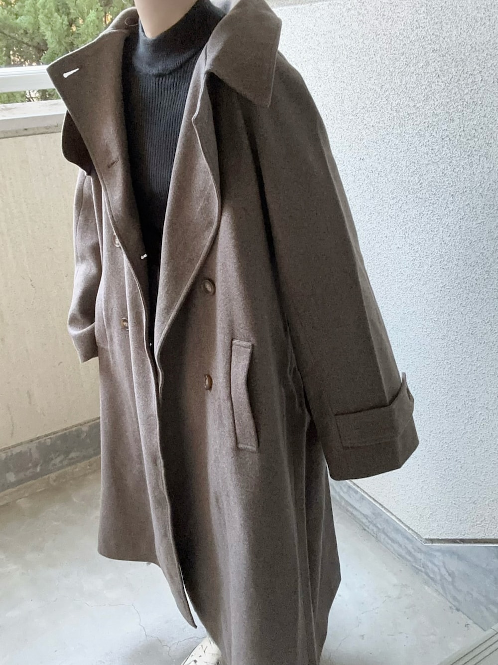 ブラウン系のチェスターコート、ブルー系のデニムパンツを着用したレディースの秋コーディネートの5枚目の写真