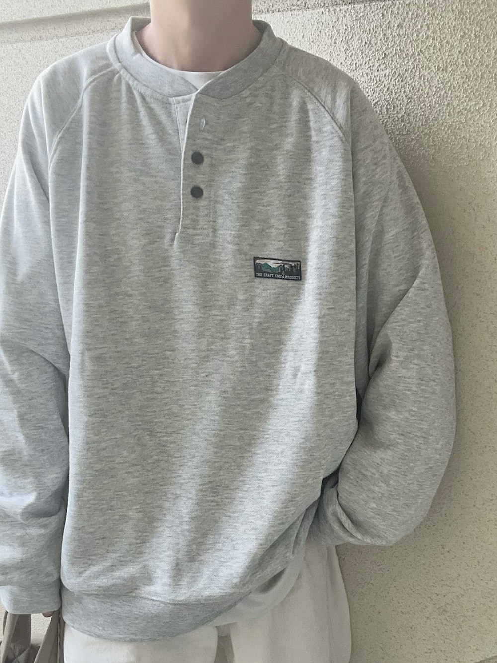 グレー系のスウェット、グリーン系のトートバッグを着用したレディースの冬コーディネートの4枚目の写真