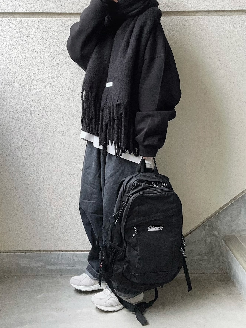 グレー系のデニムパンツ、ブラック系のスウェット、ホワイト系のTシャツ/カットソーを着用したレディースの冬コーディネートの3枚目の写真