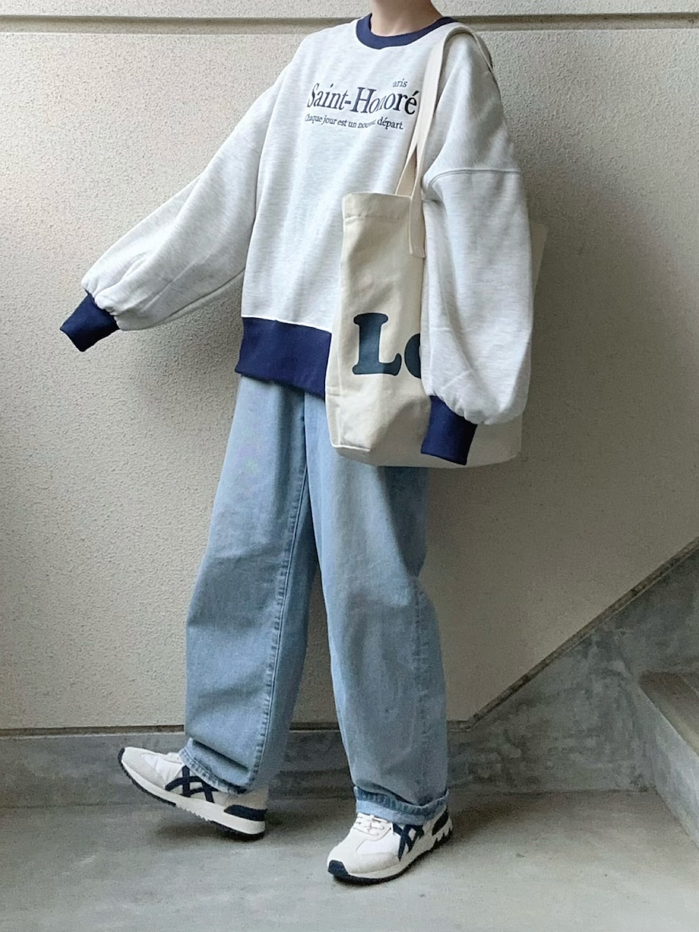 ベージュ系のスウェット、ベージュ系のスニーカー、ブルー系のデニムパンツを着用したレディースの冬コーディネートの4枚目の写真