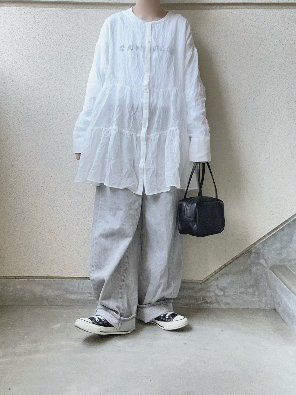 ホワイト系のシャツ/ブラウス、グレー系のデニムパンツ、ブラック系のボストンバッグを着用したレディースの春コーディネートの2枚目の写真