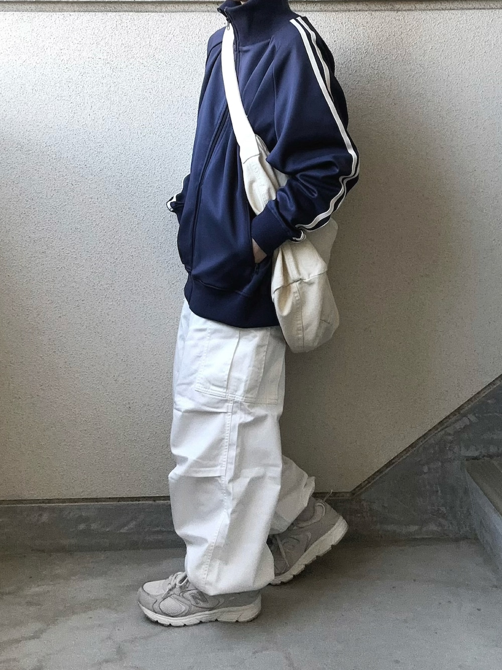 ホワイト系のカーゴパンツ、ブルー系のジャージ、グレー系のスニーカーを着用したレディースの春コーディネートの2枚目の写真