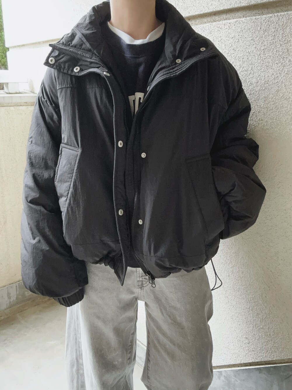 ブラック系のダウンジャケット/コート、グレー系のデニムパンツを着用したレディースの秋コーディネートの4枚目の写真