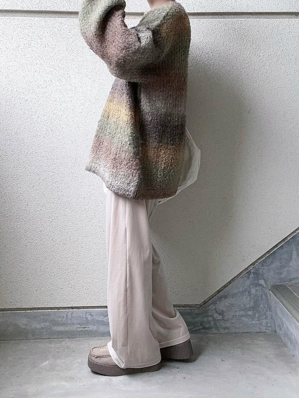 イエロー系のニット/セーター、ホワイト系のその他パンツ、ベージュ系のモカシン/デッキシューズを着用したレディースの冬コーディネートの4枚目の写真