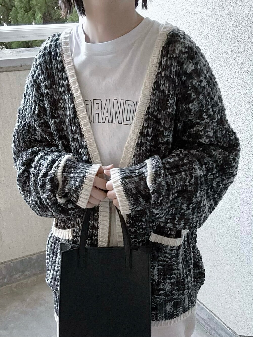 ブラック系のカーディガン/ボレロ、ホワイト系のTシャツ/カットソー、ホワイト系のデニムパンツを着用したレディースの冬コーディネートの4枚目の写真