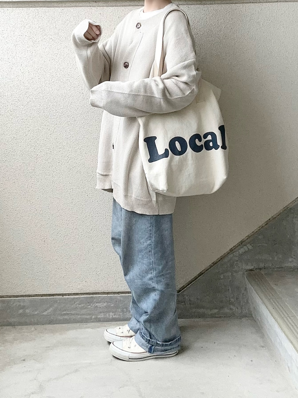 ベージュ系のカーディガン/ボレロ、ブルー系のデニムパンツ、ホワイト系のスニーカーを着用したレディースの冬コーディネートの3枚目の写真