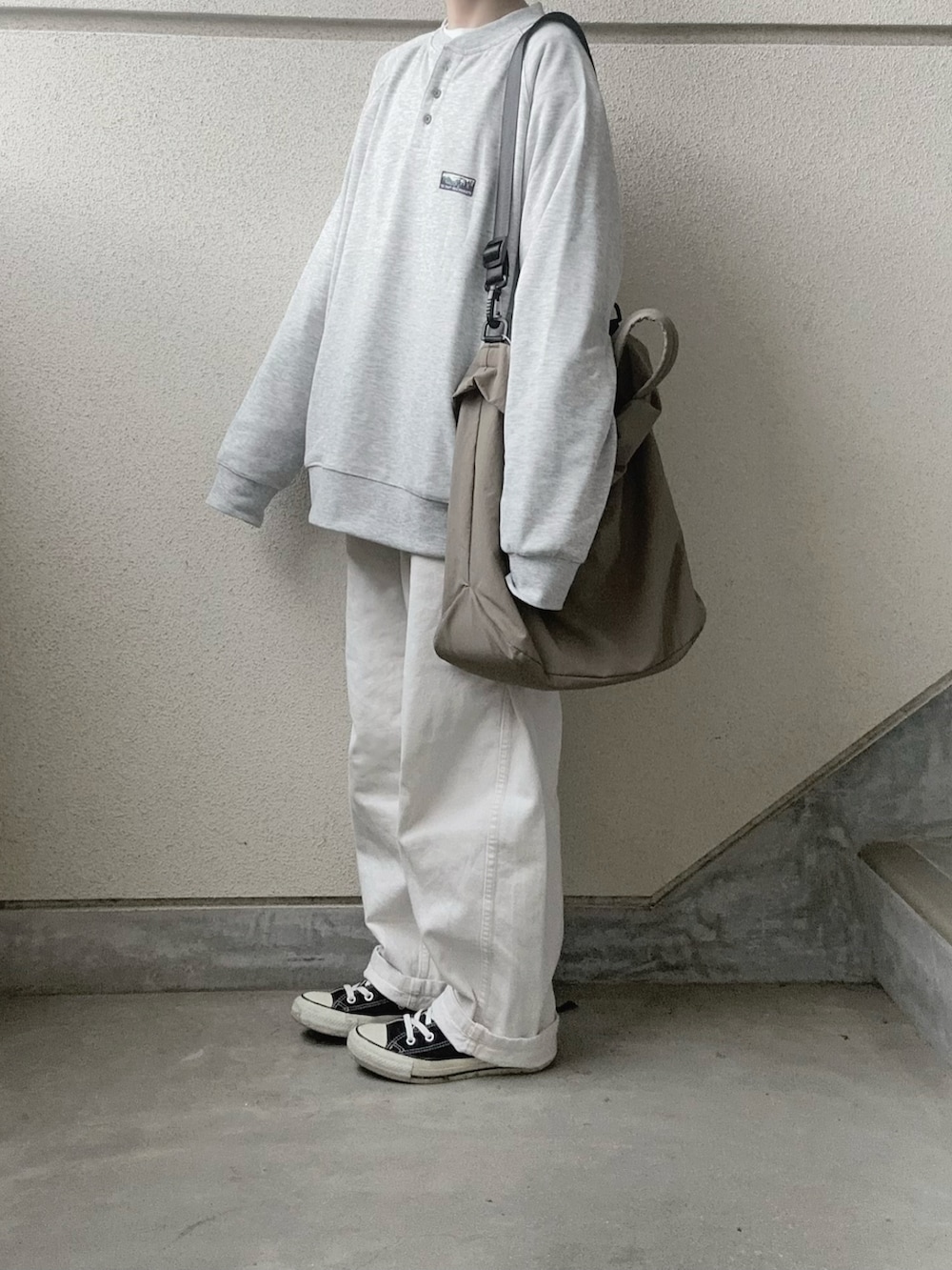 グレー系のスウェット、グリーン系のトートバッグを着用したレディースの冬コーディネートの5枚目の写真