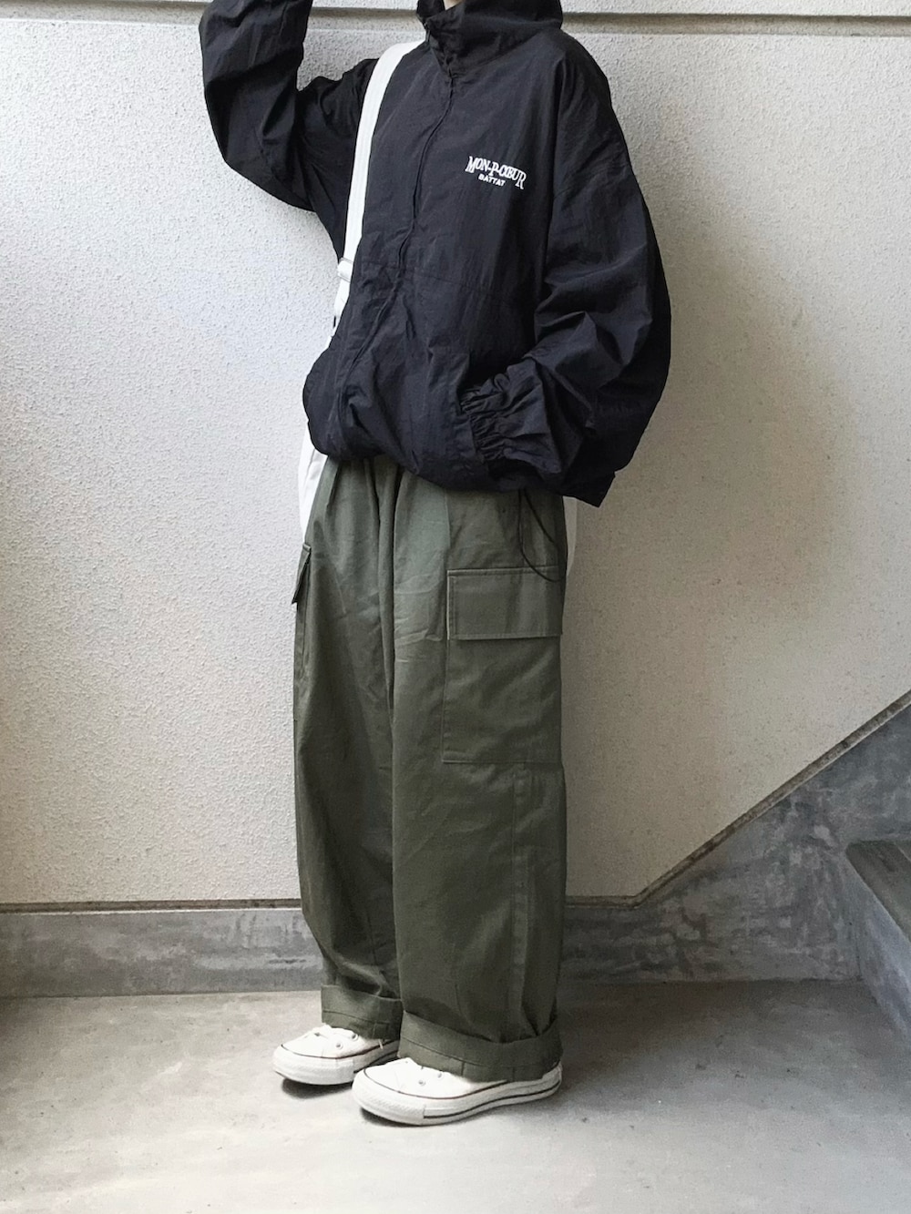 ブラック系のブルゾン、ホワイト系のショルダーバッグ、グリーン系のカーゴパンツを着用したレディースの秋コーディネートの4枚目の写真