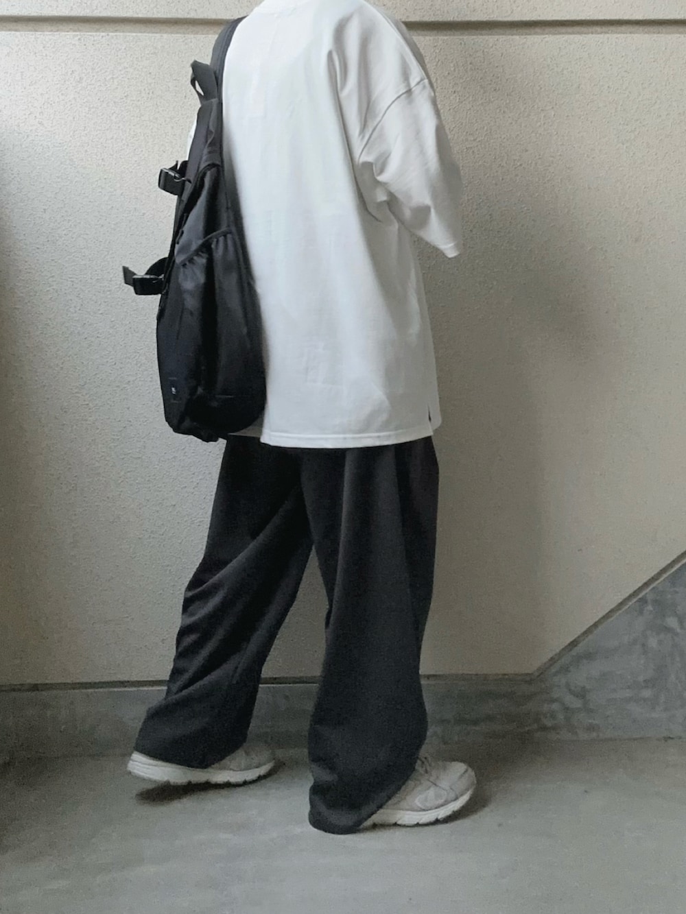 ホワイト系のTシャツ/カットソー、グレー系のスラックス、ブラック系のボディバッグ/ウエストポーチを着用したレディースの春コーディネートの4枚目の写真