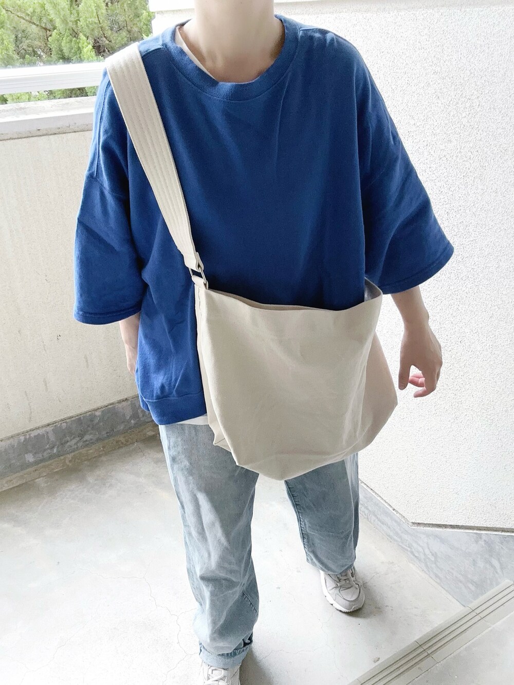 ホワイト系のショルダーバッグ、ブルー系のTシャツ/カットソーを着用したレディースの夏コーディネートの2枚目の写真