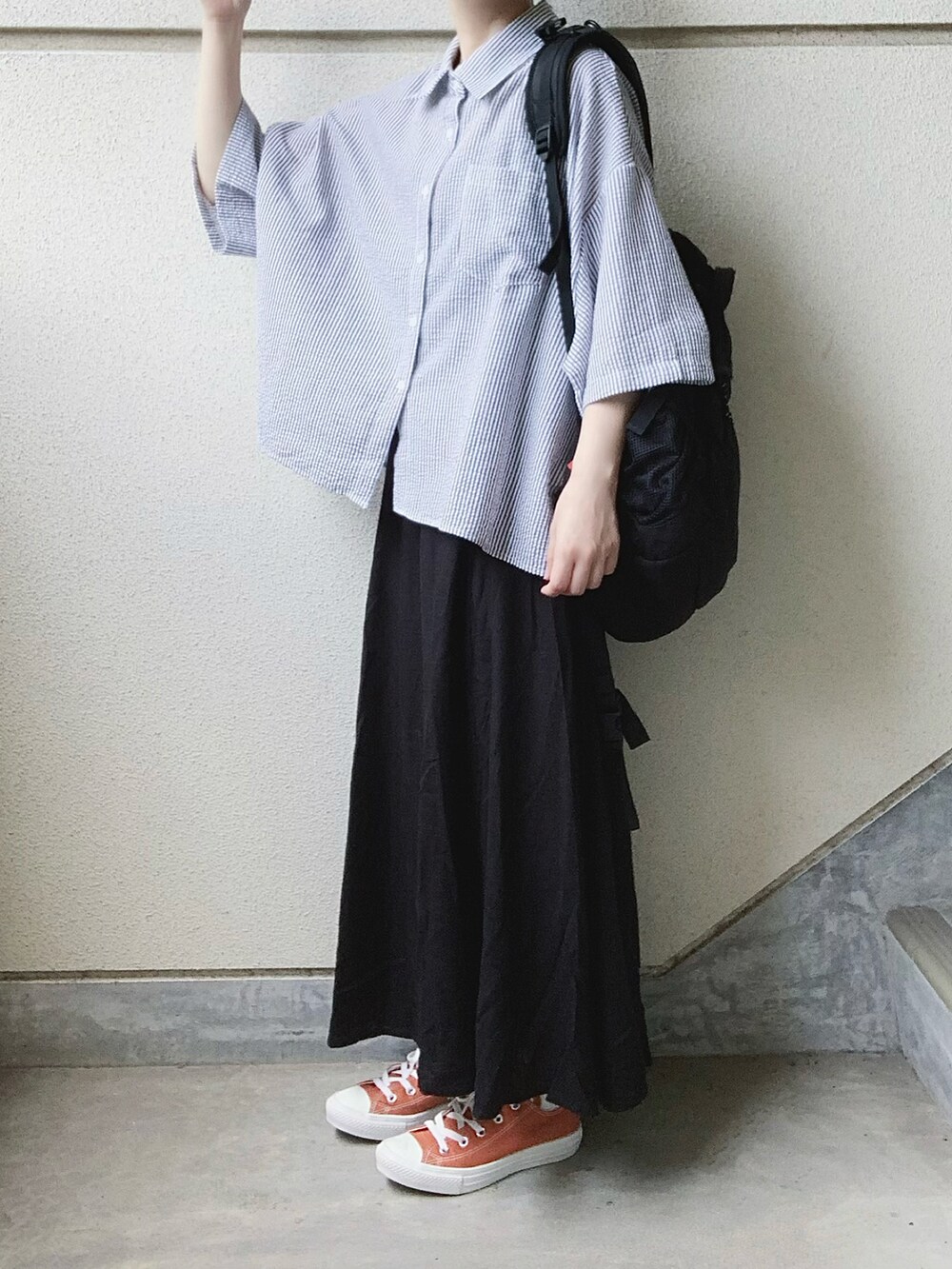 ブラック系のスカート、ブラック系のシャツ/ブラウス、オレンジ系のスニーカーを着用したレディースの夏コーディネートの2枚目の写真